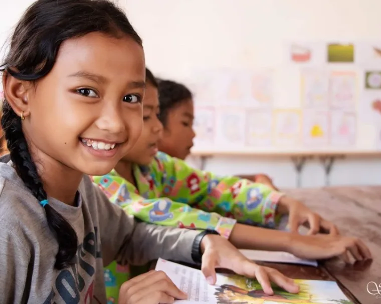 Cambodian students reading together in a bright learning space