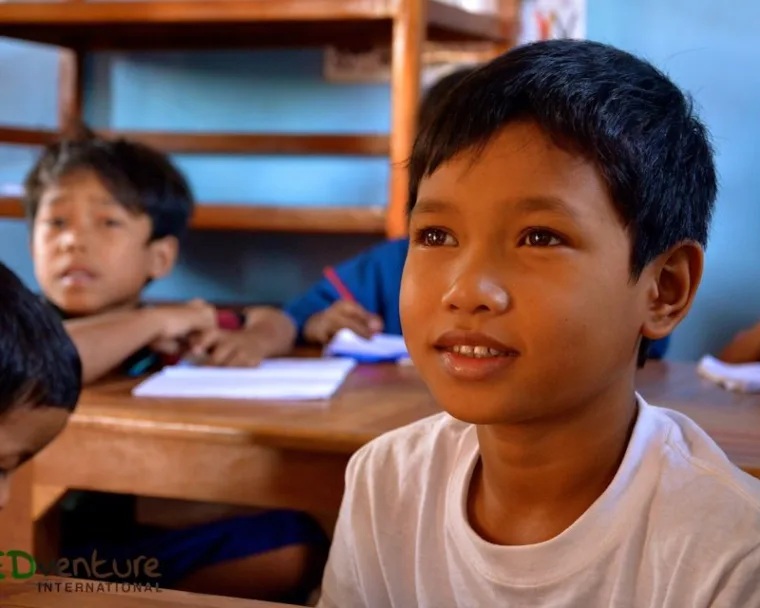 A Cambodian boy continuing his studies in class