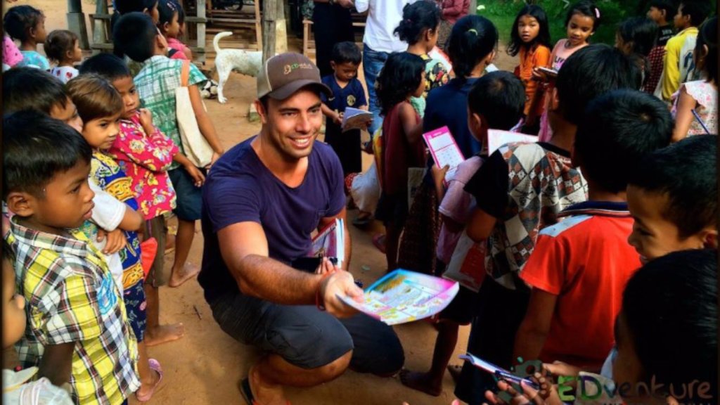 Learning materials being handed to children in the village at Phum Ou, early work of EDGE Worldwide in Cambodia