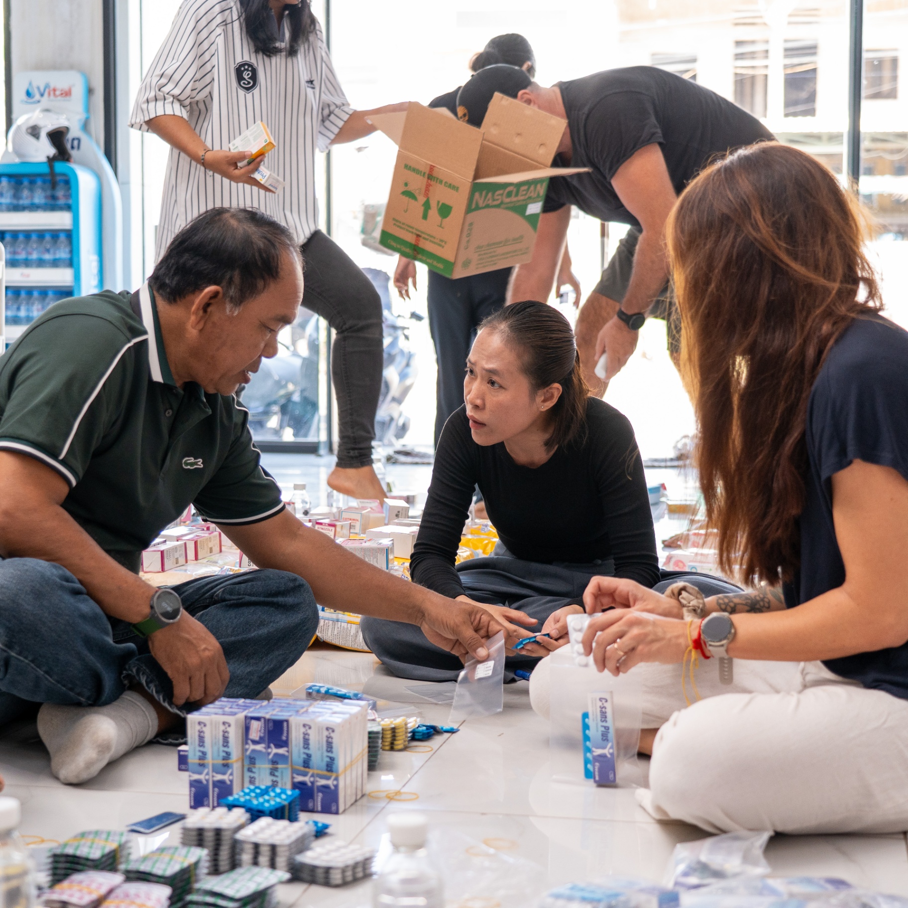 EDGE Worldwide volunteers check donated medicine while packing supply packages for displaced Cambodian families